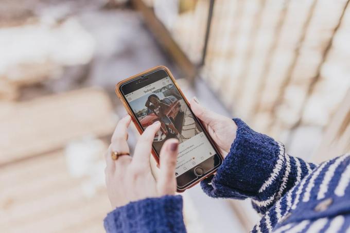 Händer som rullar genom ett Instagram -flöde